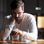 Consumo de álcool e os riscos para a saúde Upset,Young,Man,Drinker,Alcoholic,Sitting,At,Bar,Counter,With